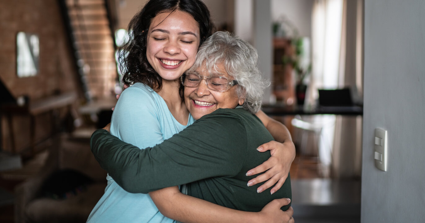 Grandmother and granddaughter embracing and smiling